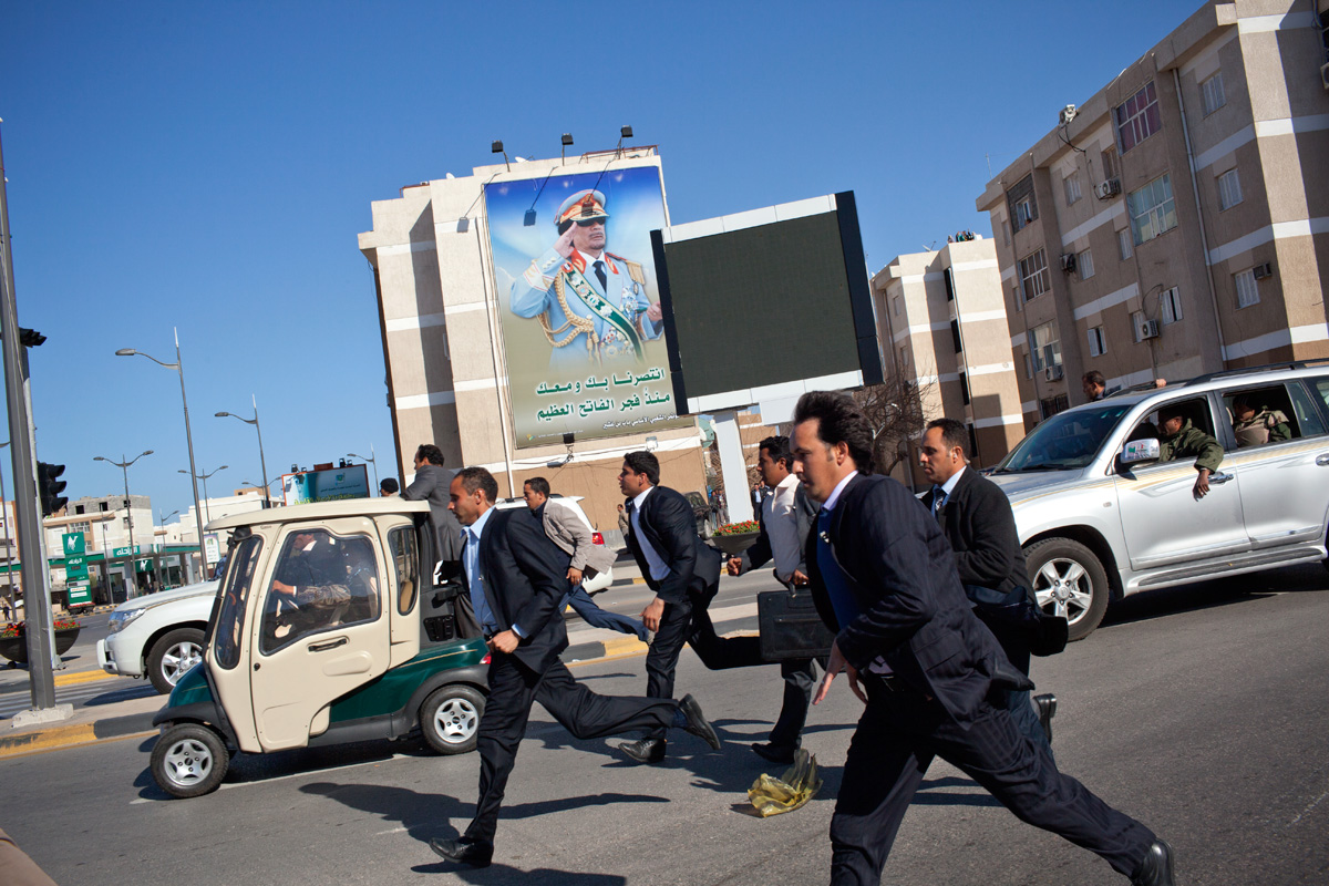 Saluted by his own effigy gracing the walls of the capital, the Colonel returns to his highly secure base Bab al-Aziziya. 