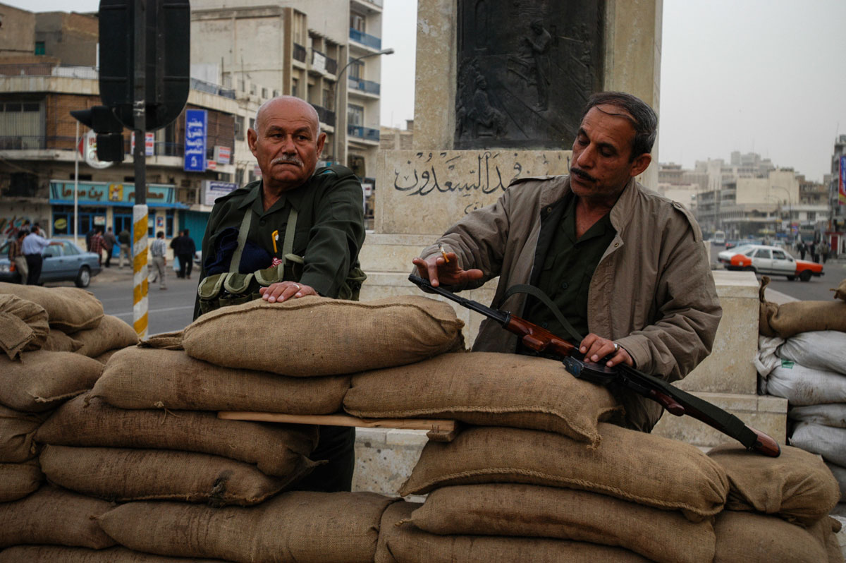 March 19th 2003.
Iraqi volunteers, stand at sandbag positions on Sadoun Street in downtown Baghdad, a few hours before the ultimatum given by President Bush to Saddam Hussein  expires.
 Their defenses seem rudimentary and inadequate to the reality of a conflict.
