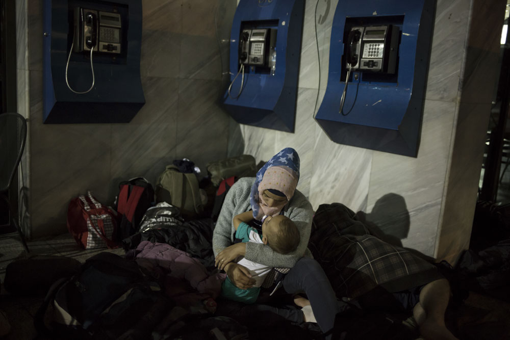 La famille syrienne passe sa première nuit dehors  dans une gare routière. Ils ont atteint une zone frontalière interdite aux migrants. Ils attendent une voiture clandestine, conduite par un passeur, pour être emmené à la frontière avec la Macédoine. Thessalonique, Grèce. 5 juillet 2015.

