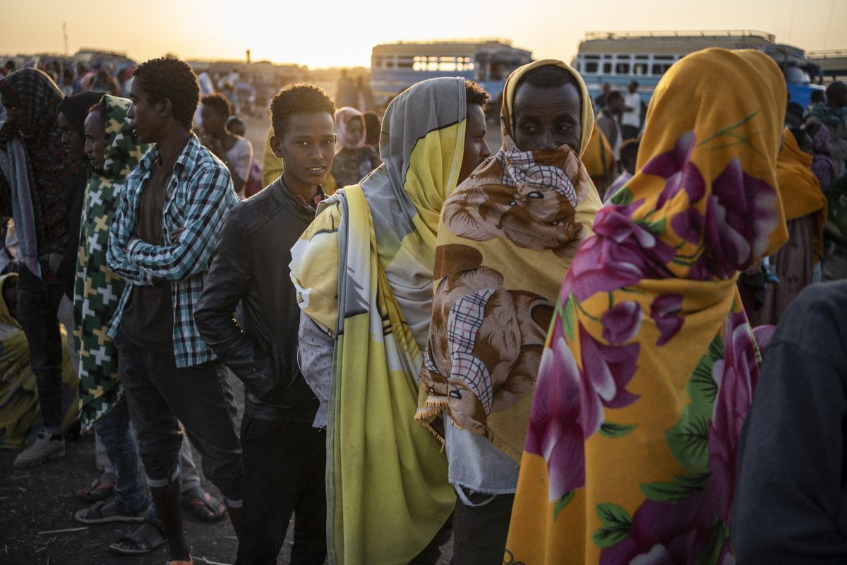 Camp de réfugiés de Hamdayet, Soudan. A l'aube, les réfugiés font la queue pour recevoir un matelas et une couverture. La journée, le baromètre peut grimper à 39 °, en revanche la nuit est glaciale. 