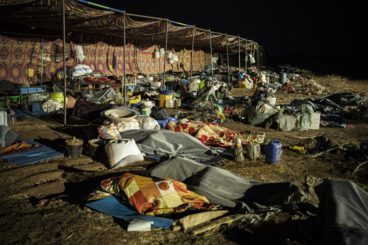 Camp de Humra Kuba, Soudan.
Arrivés après dix heures de voyage en bus, les réfugiés éthiopiens atteignent leur nouveau lieu de vie. Plus aménagé, il a vocation à les accueillir plus longtemps. Au petit matin, les nouveaux arrivants dorment encore. 