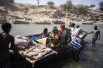 La rivière Tekeze, côté soudanais. Ces mamans  laissent derrière elles l’Éthiopie en guerre (qu’on peut apercevoir en arrière-plan). La plupart des réfugiés du Tigré empruntent ce passage surveillé par l’armée pour entrer au Soudan, vers le camp de Hamdayet. 